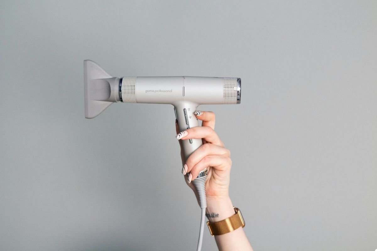 A person holding a hair dryer, preparing to style their hair with focused intent.